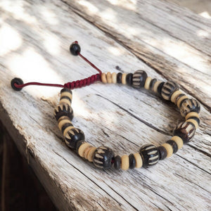Bracelet bouddhiste en perles naturelles noires et crème, cordon rouge, artisanat tibétain