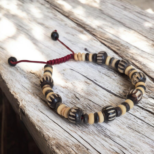 Bracelet bouddhiste en perles naturelles noires et crème, cordon rouge, artisanat tibétain