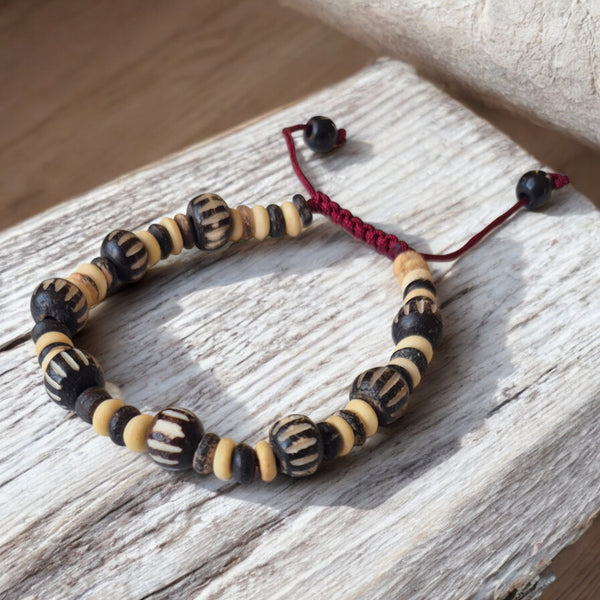 Bracelet bouddhiste en perles naturelles noires et crème, cordon rouge, artisanat tibétain
