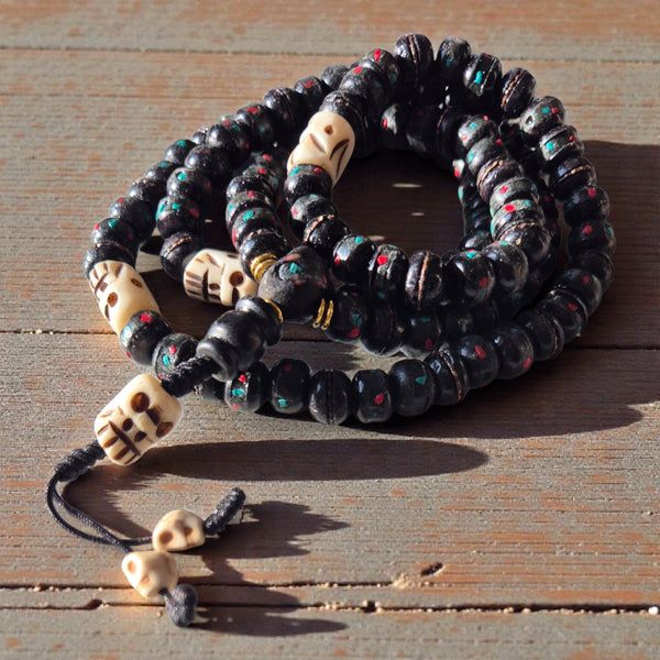 Mala bouddhiste tibétain avec perles noires et crânes, symbole de méditation et philosophie bouddhiste