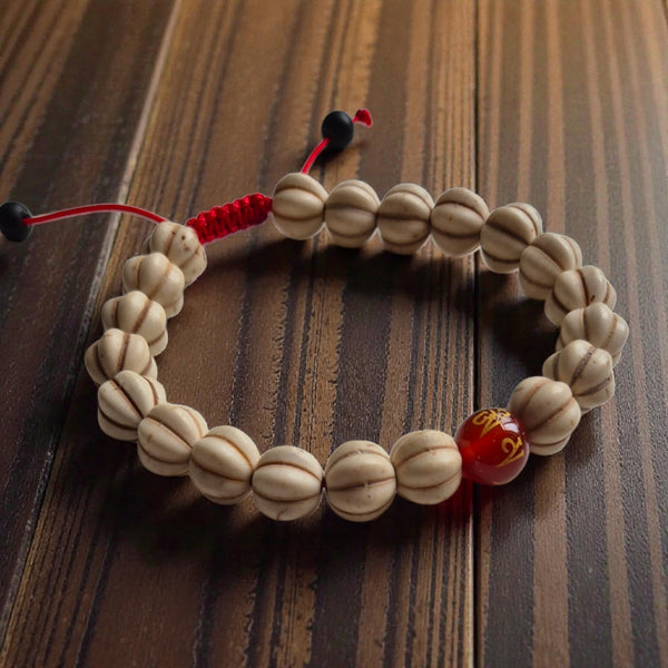 Bracelet de méditation bouddhiste en graines avec perle rouge et nœud tibétain sur bois