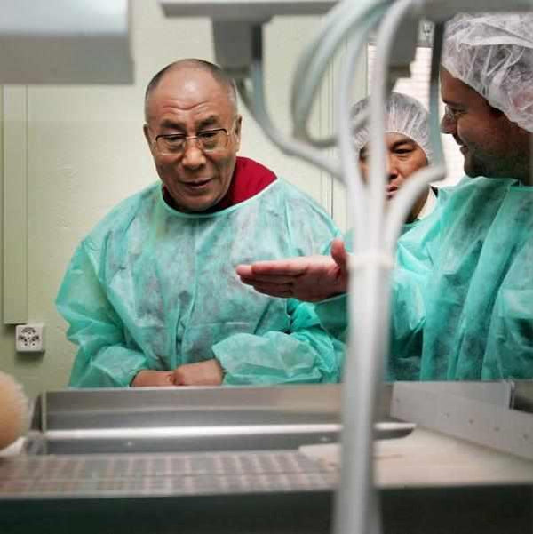 Lama en tenue médicale tibétaine discutant avec équipe dans laboratoire
