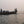 Bateau traditionnel sur un fleuve au crépuscule, passagers et rameurs en silhouette