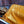 Statue bouddhiste couchée en or, recouverte d'un tissu doré, entourée de fidèles en prière.