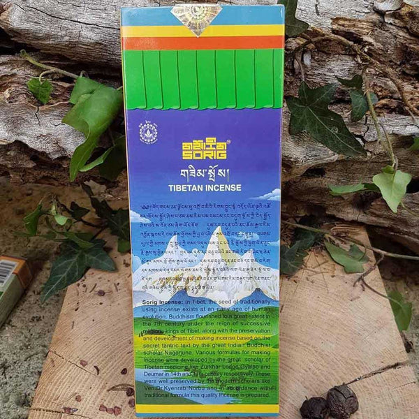 Encens tibétain Sorig, produit naturel de médecine tibétaine, avec texte en tibétain et anglais sur fond de bois et feuilles