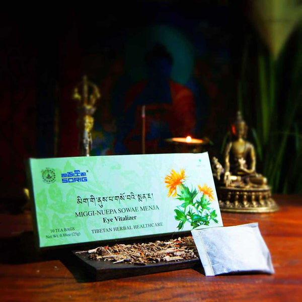 Thé tibétain MIGGI-NUEPA SOWAE MENJA pour les yeux, soin herbal traditionnel avec statuette bouddhiste en arrière-plan
