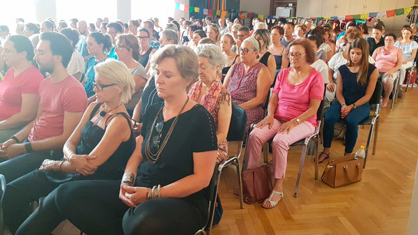 Groupe en méditation lors d'une conférence bouddhiste avec drapeaux tibétains