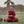 Moine bouddhiste en robe rouge méditant sur l'herbe près d'une stupa, avec palmier et culture tibétaine