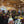 Conférence de méditation bouddhiste avec public dans salle en bois, drapeaux tibétains et enseignement spirituel