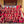 Groupe de moines bouddhistes tibétains en robes rouges sur les marches d'un temple, avec visiteurs