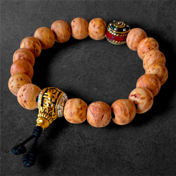 Bracelet bouddhiste en perles naturelles avec pendentif doré et tassel, inspiré de la culture tibétaine
