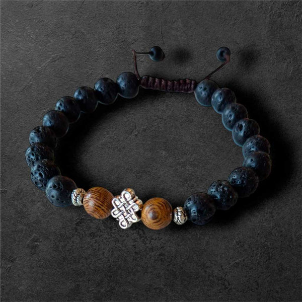 Bracelet bouddhiste en lave et bois avec nœud mystique, symbole de méditation et sagesse tibétaine