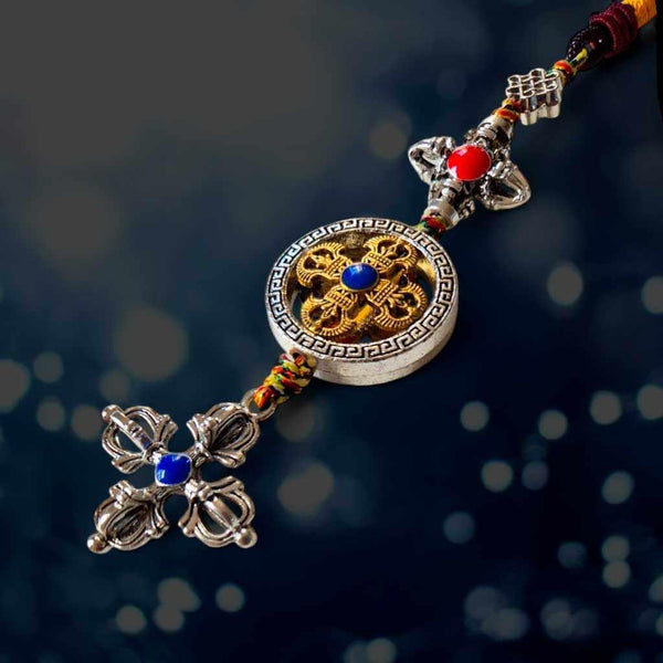 Amulette bouddhiste tibétaine avec symboles dorés et pierres précieuses