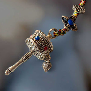 Moulin à prières tibétain en métal orné, perles colorées, symbole bouddhiste pour méditation et spiritualité