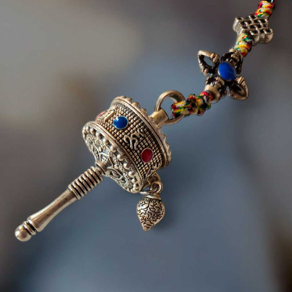 Moulin à prières tibétain en métal orné, perles colorées, symbole bouddhiste pour méditation et spiritualité