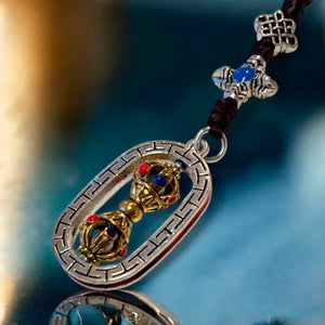Pendentif bouddhiste tibétain avec vajra doré et pierres colorées, symbole de la philosophie bouddhiste