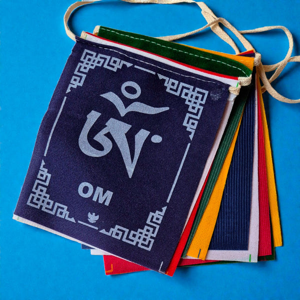 Drapeaux de prière tibétains colorés avec symbole Om, objets bouddhistes traditionnels