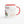 Tasse bouddhiste blanche avec intérieur rouge, inscriptions 'Compassion' et 'Amour' en tibétain, motifs floraux.