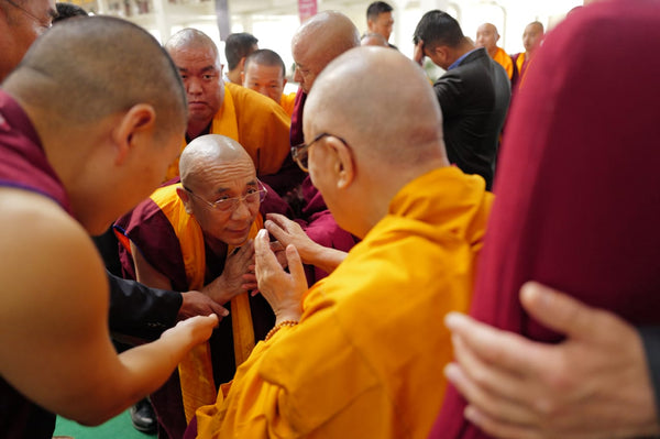Moines bouddhistes tibétains en robes safran et bordeaux lors d'une rencontre spirituelle