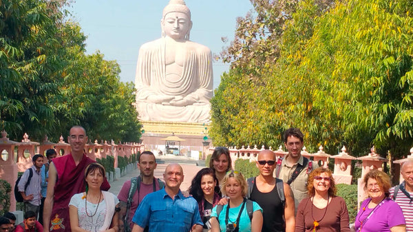 Groupe devant une grande statue de Bouddha, voyage spirituel en Inde, méditation et culture bouddhiste