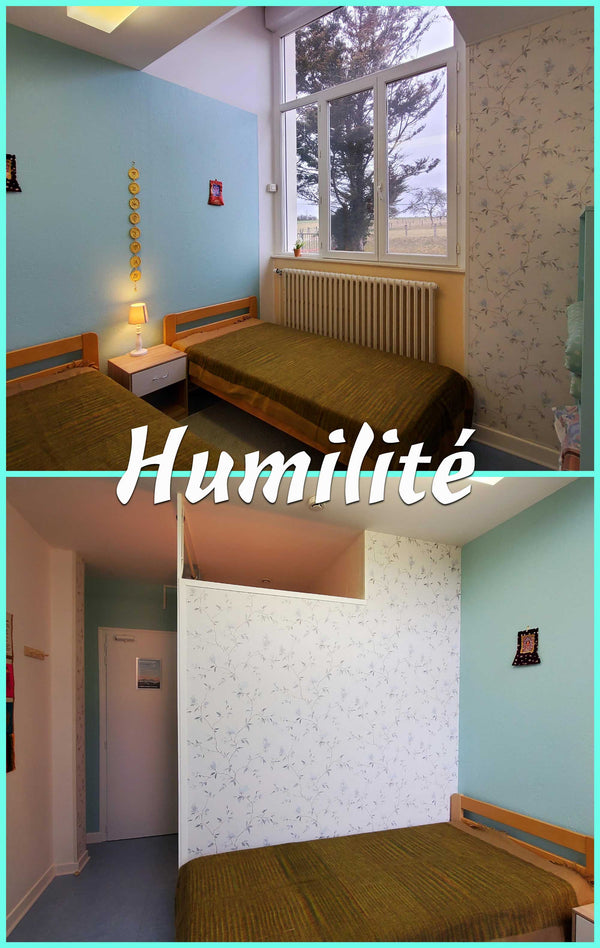Chambre simple avec lits, décoration bouddhiste et vue sur nature, idéale pour la méditation et l'humilité