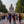 Statue géante de Bouddha assis, pèlerins marchant sur allée bordée d'arbres, symbole de méditation et sérénité