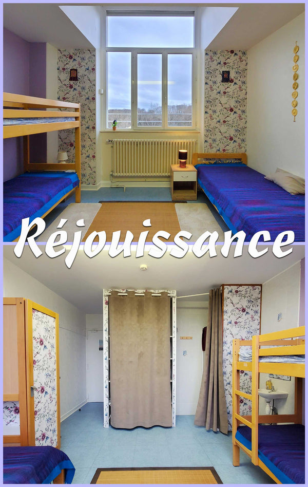 Chambre de retraite bouddhiste avec lits superposés, tapis de méditation et décoration tibétaine, vue sur forêt