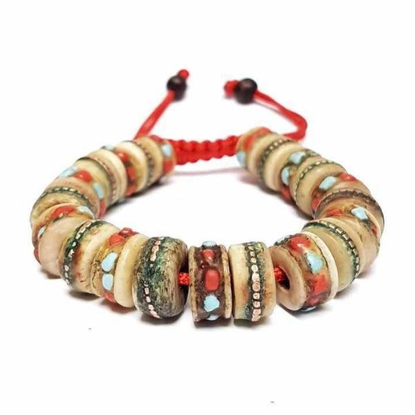Bracelet tibétain artisanal avec perles colorées et cordon rouge, inspiré de la culture bouddhiste