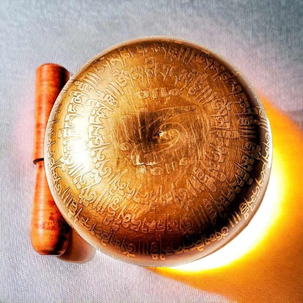 Bol tibétain gravé avec symboles bouddhistes et maillet en bois, objet de méditation et de bien-être