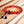 Bracelet de méditation en perles d'ambre rouge avec nœud noir, posé sur bois clair