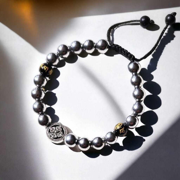 Bracelet bouddhiste en perles métalliques avec symboles tibétains et nœud ajustable
