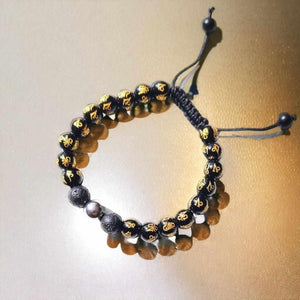Bracelet bouddhiste tibétain avec perles noires gravées de symboles dorés et cordon ajustable