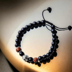 Bracelet bouddhiste en perles noires avec éléphant argenté et perles rouges, symbole de sagesse et méditation