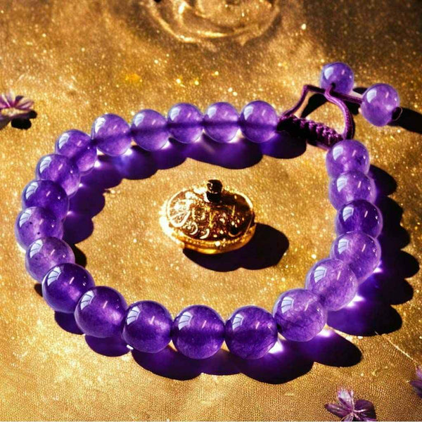 Bracelet en améthyste violette avec perles bouddhistes et pendentif doré, symbole de méditation et sérénité