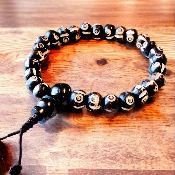 Bracelet bouddhiste tibétain à perles noires et motifs d'yeux, symbole de protection et de sagesse