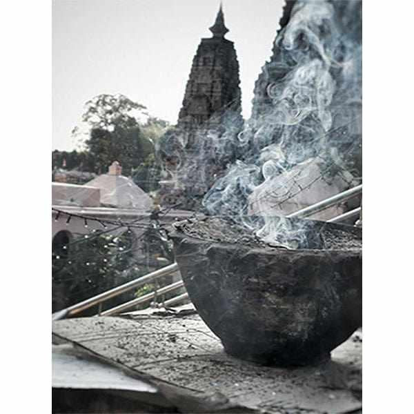 Encens fumant devant stupa bouddhiste, symbole de méditation et culture tibétaine