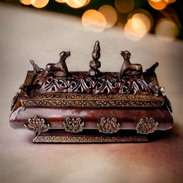 Boîte à encens bouddhiste tibétaine en pierre et métal, ornée de motifs traditionnels et de figurines de cerfs.