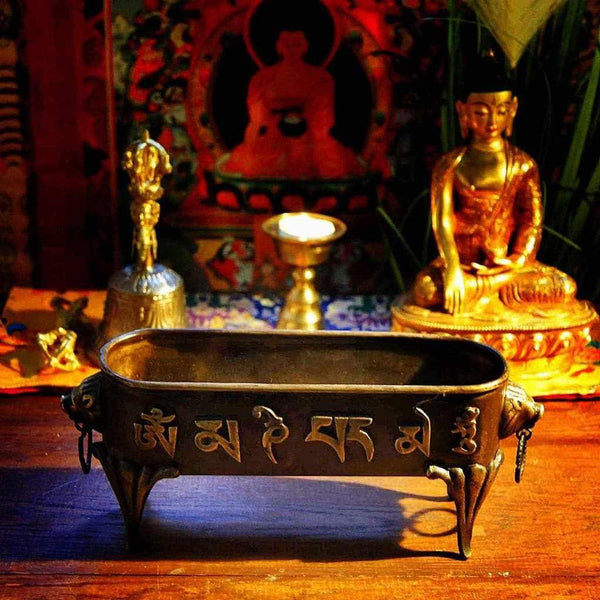 Brûle-parfum bouddhiste tibétain avec inscriptions sacrées, statue de Bouddha dorée et lampe à huile