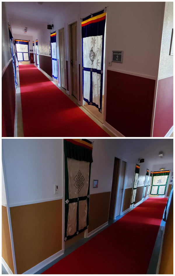 Couloir avec tapis rouge et rideaux tibétains colorés, symboles bouddhistes, ambiance méditation