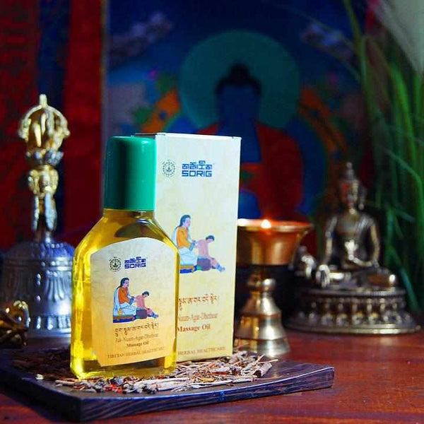 Huile de massage tibétaine Sorig, produit naturel de médecine tibétaine, avec statuette bouddhiste et offrandes