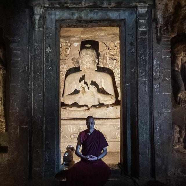 Moine bouddhiste en méditation devant statue de Bouddha dans temple ancien, philosophie tibétaine