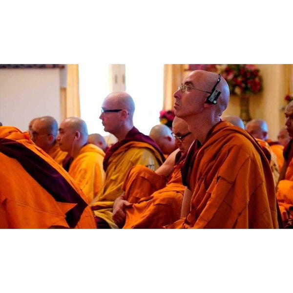 Moines bouddhistes en robes orange lors d'une méditation ou conférence sur la philosophie tibétaine