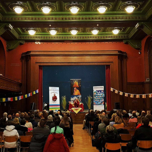 Conférence de méditation bouddhiste avec Lama Samten, drapeaux tibétains et livres de philosophie bouddhiste
