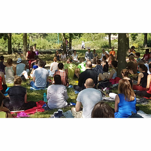 Groupe en méditation bouddhiste en plein air, cercle sous les arbres, pratique spirituelle en nature
