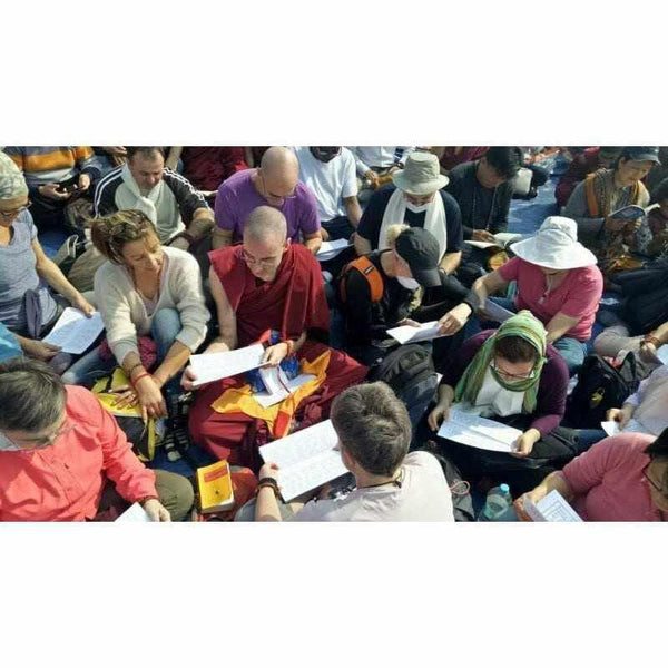 Groupe en méditation bouddhiste avec moine tibétain, livres et textes philosophiques