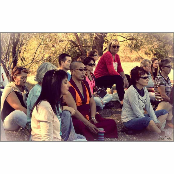Groupe en méditation bouddhiste en plein air avec moine tibétain, philosophie et sérénité naturelle