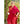 Lama bouddhiste en robe rouge, souriant en extérieur, symbole de sagesse tibétaine