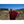 Lama bouddhiste en robe rouge dans un vignoble, montagnes en arrière-plan, méditation et philosophie tibétaine