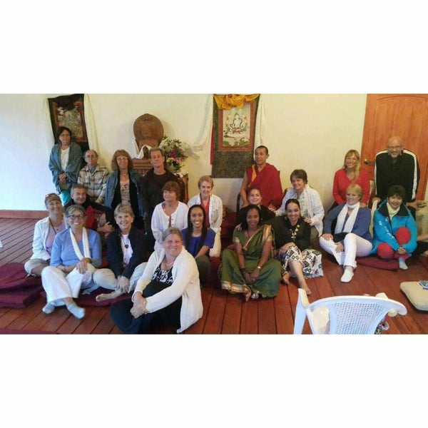Groupe en méditation bouddhiste avec lama, tapis et thangkas tibétains, culture spirituelle de l'Himalaya