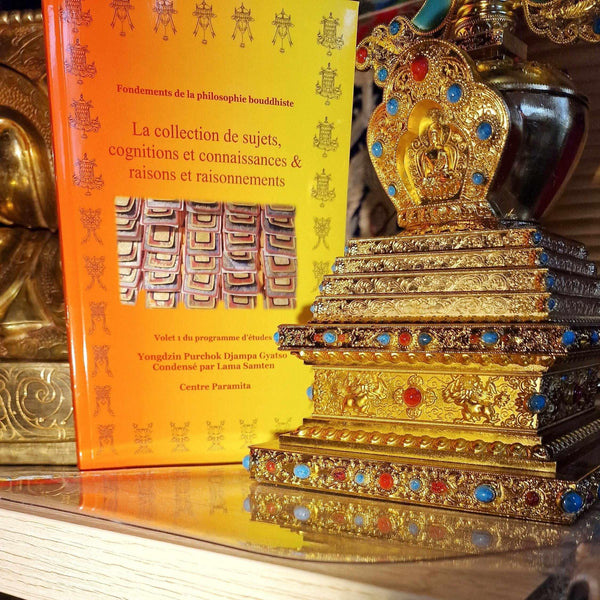 Livre de philosophie bouddhiste et stupa doré orné de pierres, objets de méditation et culture tibétaine